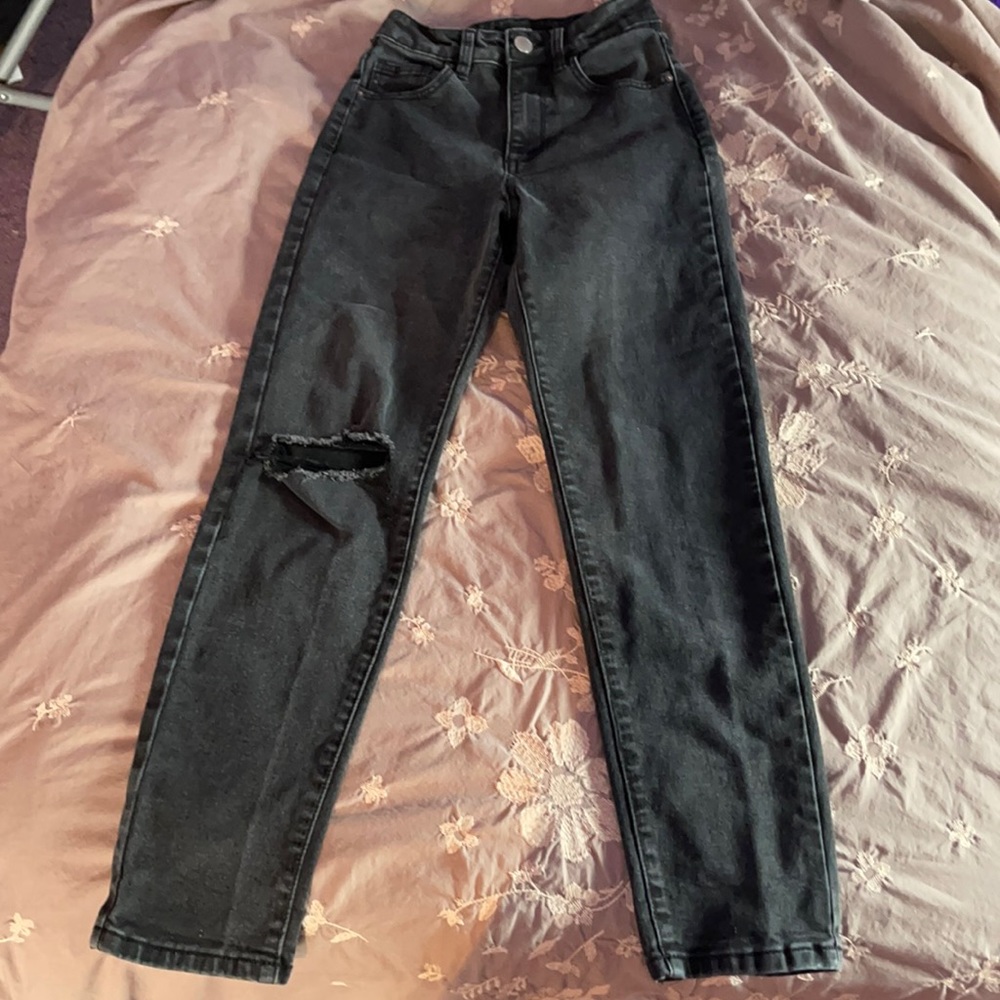Black stretch mom jeans, rip style on right knee.